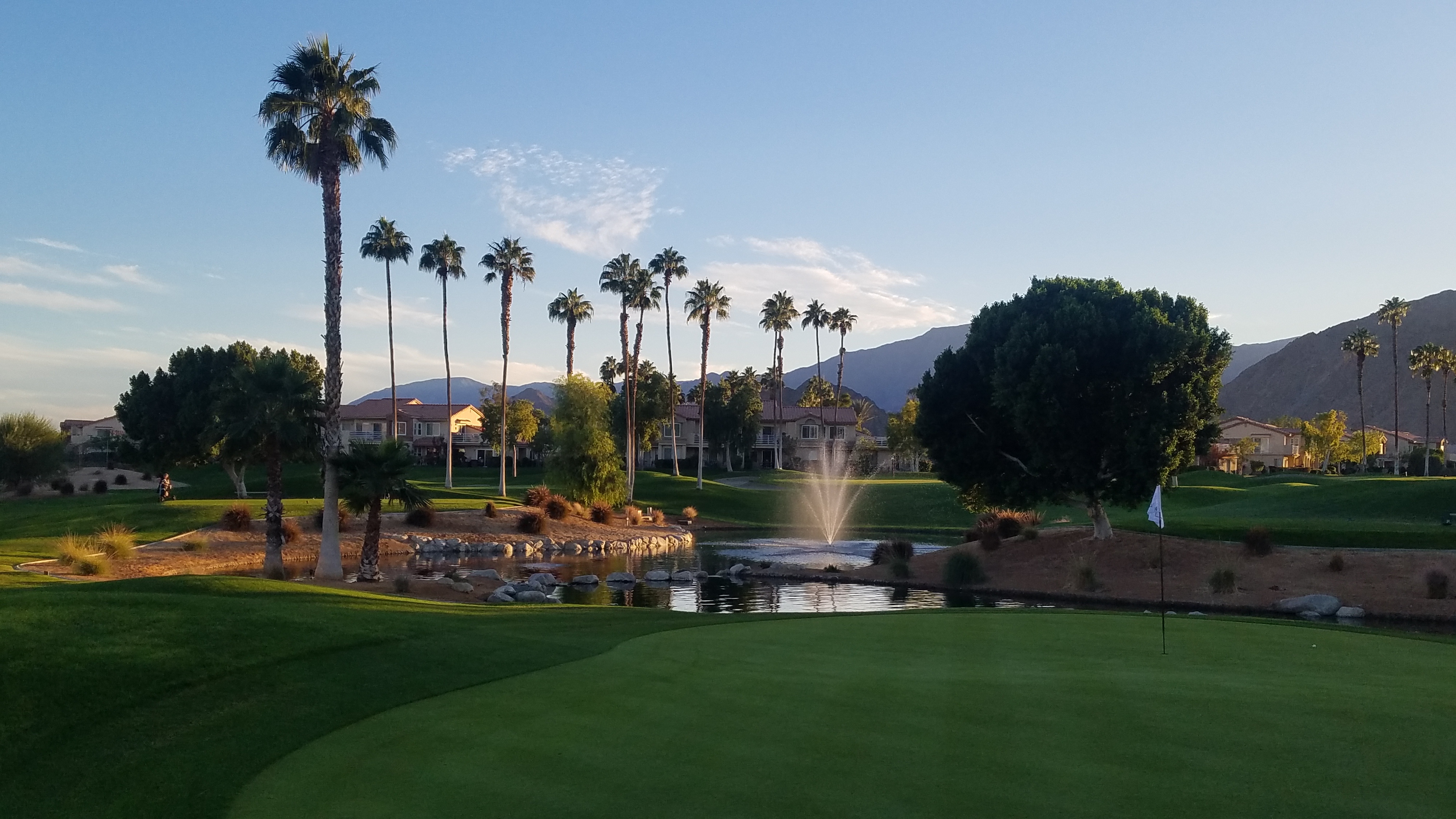 Palm Royale golf course with lake, homes, and mountains